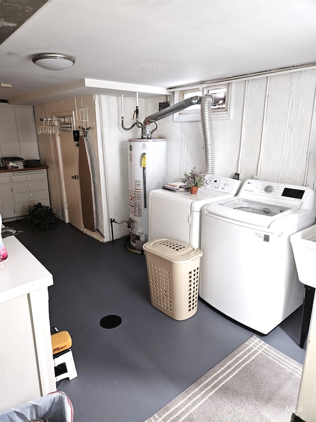 clothes washing area featuring water heater and independent washer and dryer