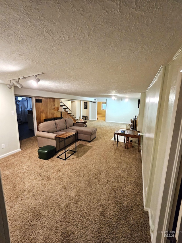 living room with carpet, track lighting, and a textured ceiling