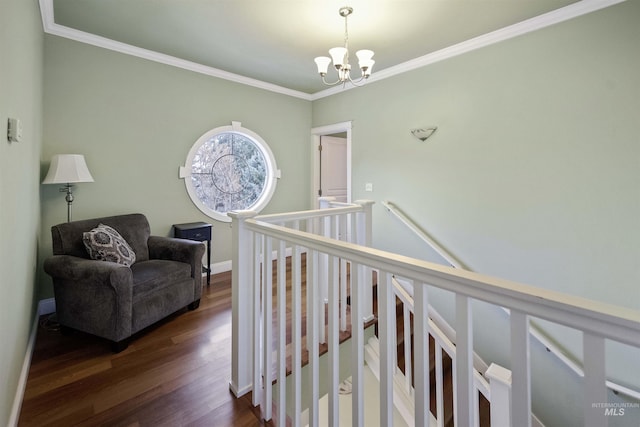 corridor with crown molding, a notable chandelier, dark wood finished floors, and baseboards