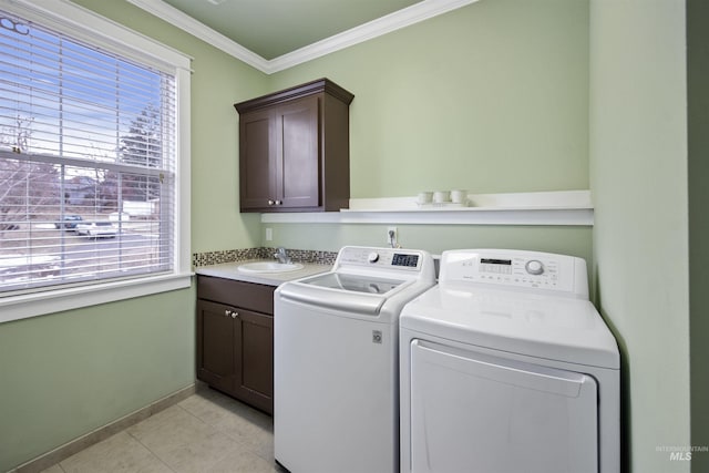 laundry room featuring cabinet space, crown molding, washer and dryer, a sink, and light tile patterned flooring