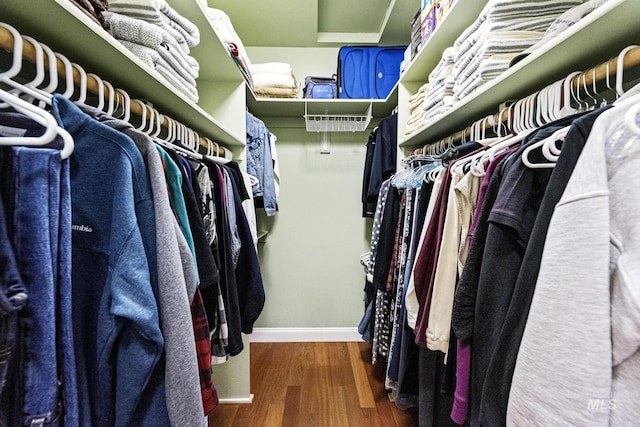 walk in closet with wood finished floors