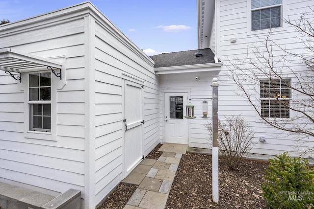 entrance to property with a shingled roof