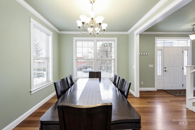 dining room with dark wood-style floors, baseboards, a chandelier, and crown molding