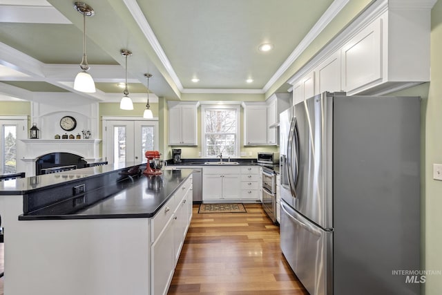 kitchen featuring dark countertops, white cabinetry, appliances with stainless steel finishes, and wood finished floors