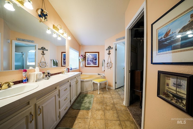 full bath with vaulted ceiling, a garden tub, a sink, and double vanity