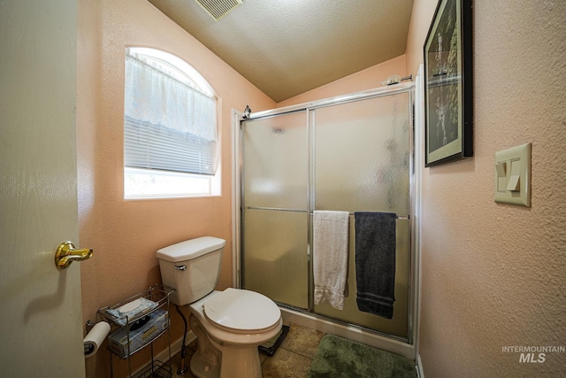 bathroom with toilet, a textured wall, a shower stall, and visible vents