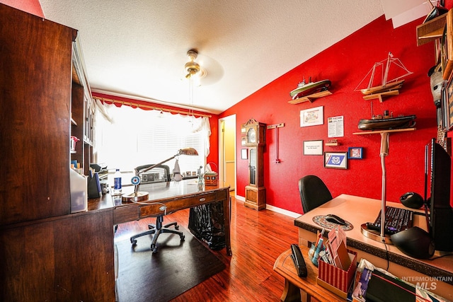 office area featuring a textured ceiling, ceiling fan, wood finished floors, baseboards, and vaulted ceiling