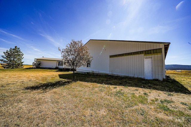 view of side of property with an outbuilding, a yard, and a detached garage