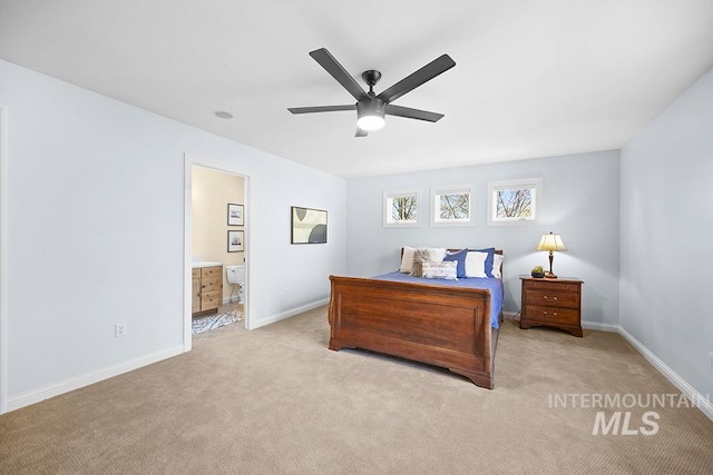 bedroom with connected bathroom, baseboards, and carpet