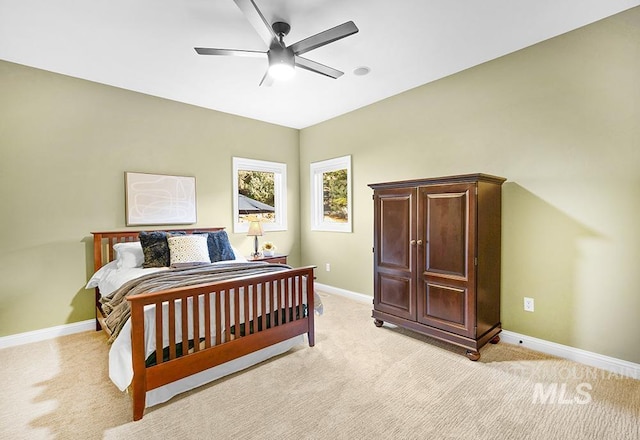 bedroom with baseboards, ceiling fan, and light colored carpet