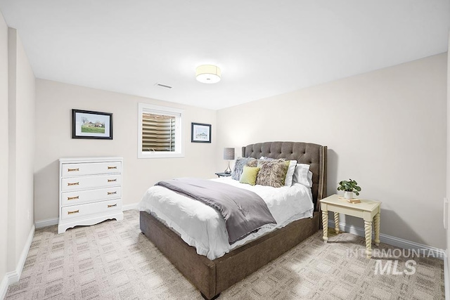 carpeted bedroom featuring baseboards and visible vents