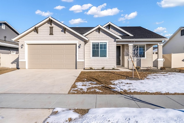 craftsman inspired home with a garage, roof with shingles, concrete driveway, and fence