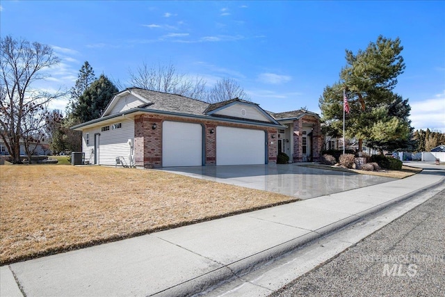 ranch-style home with central AC unit, an attached garage, brick siding, concrete driveway, and a front lawn