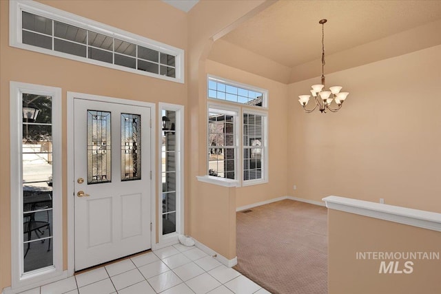 entrance foyer with light carpet, light tile patterned floors, baseboards, visible vents, and a chandelier