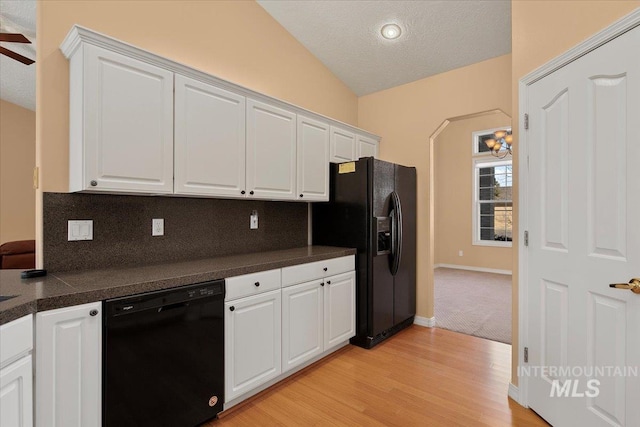 kitchen with decorative backsplash, dark countertops, lofted ceiling, black appliances, and white cabinetry