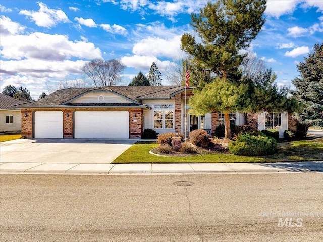 view of front of home featuring a garage, brick siding, and driveway