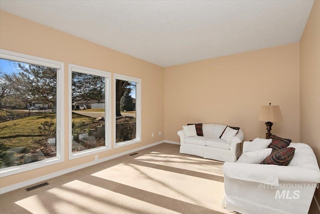 living room with carpet, a healthy amount of sunlight, and visible vents