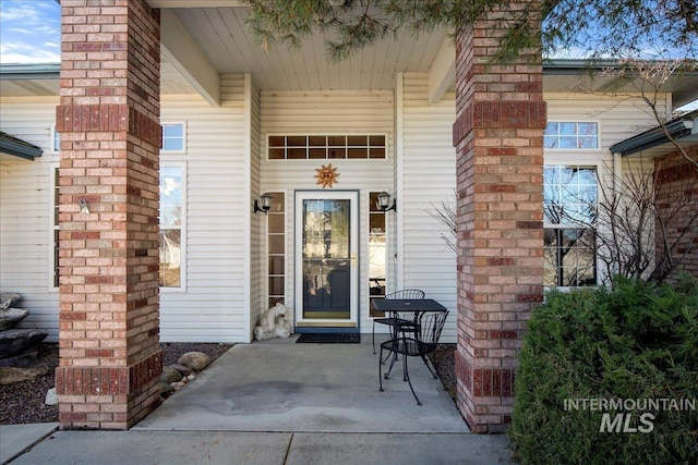 view of exterior entry with brick siding