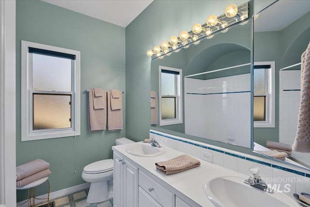 bathroom featuring a shower, a sink, and toilet