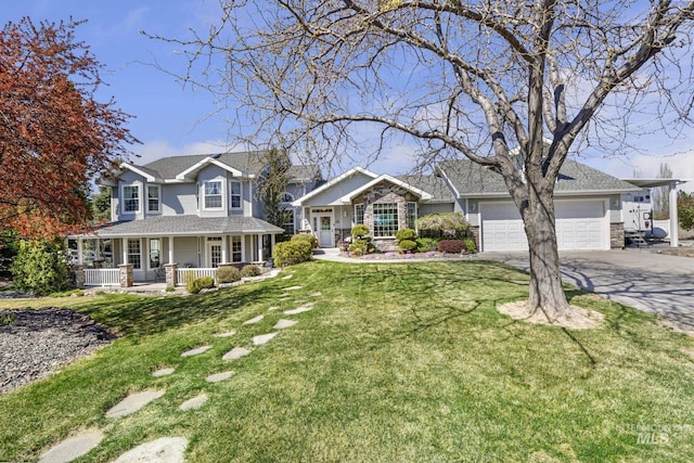 view of front of property with concrete driveway, a front lawn, a shingled roof, covered porch, and a garage