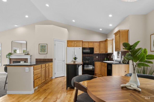 5873 N Collister Dr, Boise, ID 83703 - kitchen featuring black appliances, a sink, lofted ceiling, light wood-style flooring, and dark countertops