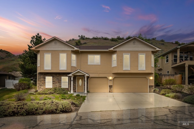 5873 N Collister Dr, Boise, ID 83703 - view of front of property with stone siding, an attached garage, and concrete driveway