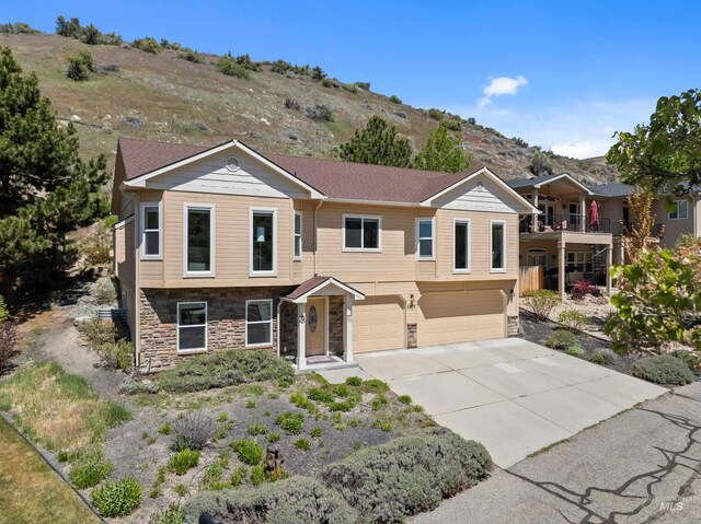 5873 N Collister Dr, Boise, ID 83703 - view of front of property with stone siding, an attached garage, driveway, and a mountain view