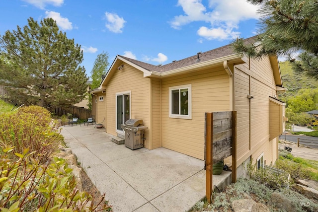 5873 N Collister Dr, Boise, ID 83703 - view of side of home with a patio, fence, and a shingled roof