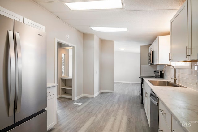 347 Winona Dr, Fairfield, ID 83327 - kitchen with light stone countertops, appliances with stainless steel finishes, a sink, light wood finished floors, and decorative backsplash