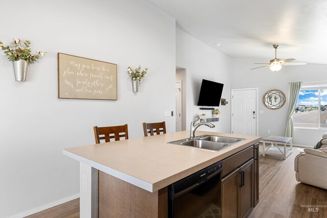kitchen featuring ceiling fan, vaulted ceiling, a sink, open floor plan, and black dishwasher