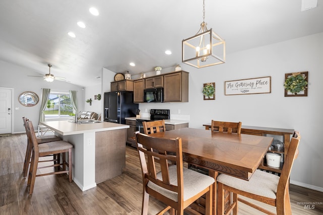 dining area with ceiling fan with notable chandelier, vaulted ceiling, recessed lighting, and dark wood-style floors