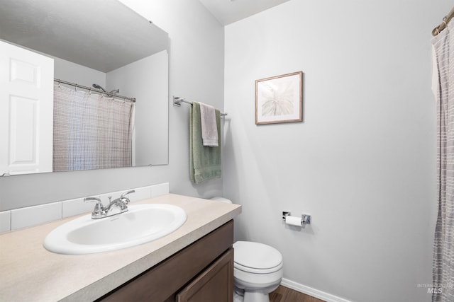 full bathroom with vanity, baseboards, and toilet