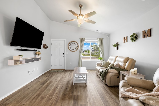 living room featuring baseboards, ceiling fan, wood finished floors, and vaulted ceiling