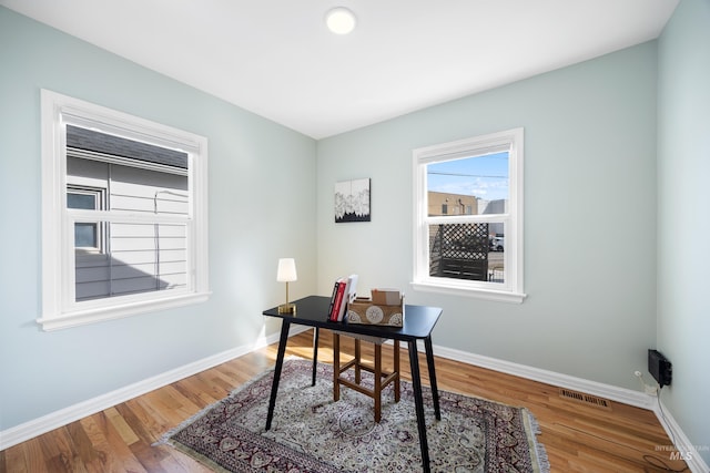 office featuring visible vents, wood finished floors, and baseboards