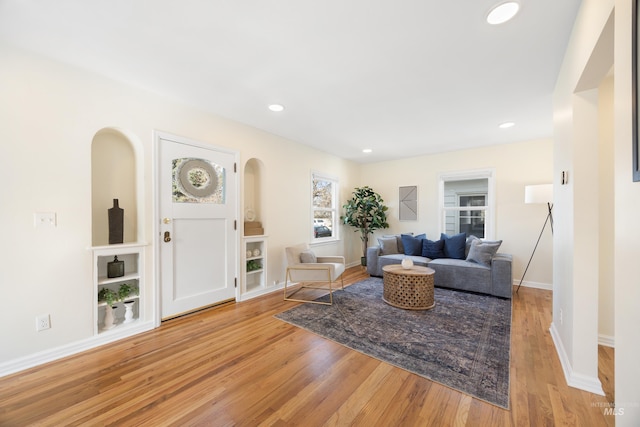 living area featuring recessed lighting, baseboards, and light wood finished floors