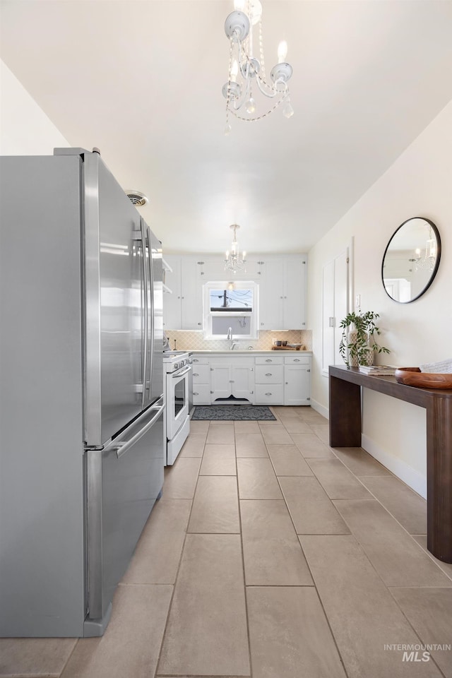 kitchen with white cabinetry, white range with electric stovetop, freestanding refrigerator, an inviting chandelier, and light countertops