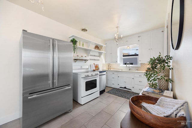 kitchen with white electric range oven, a sink, stainless steel fridge, white cabinets, and tasteful backsplash