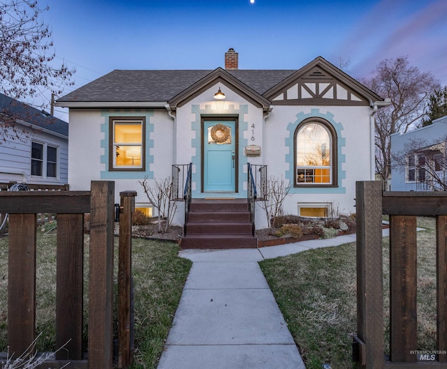 view of front of house with stucco siding, roof with shingles, a chimney, and fence