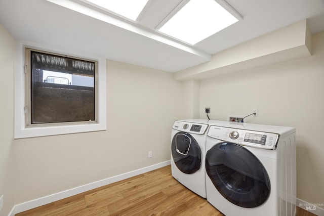 laundry room with light wood finished floors, laundry area, independent washer and dryer, and baseboards