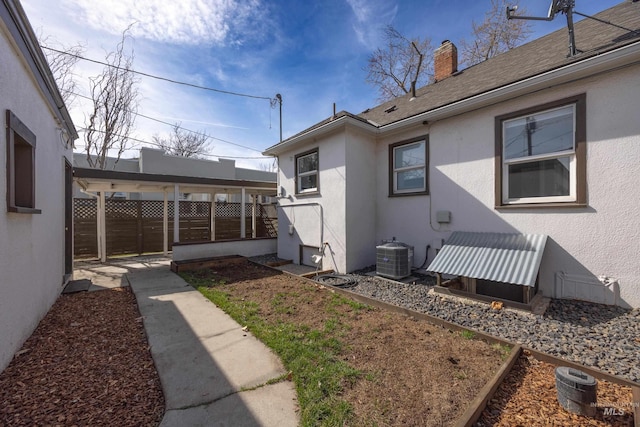 view of yard with central AC and fence