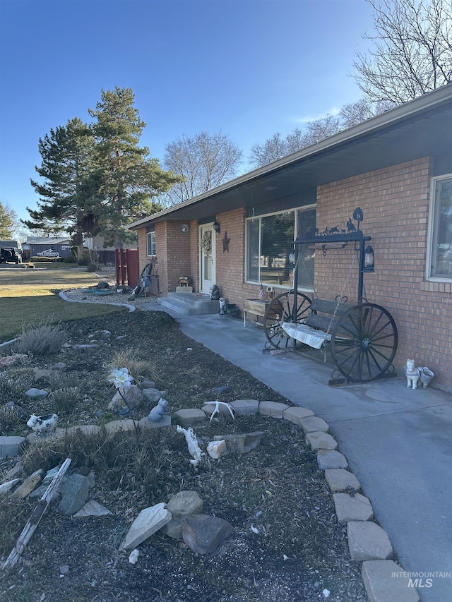 view of front of house with a patio and brick siding