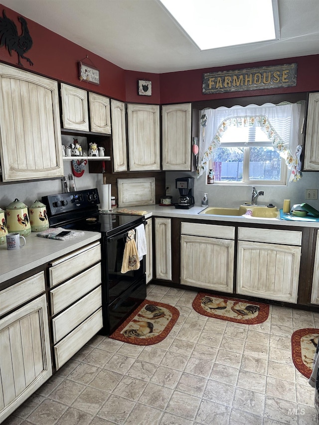 kitchen with a sink, light brown cabinetry, light countertops, black electric range oven, and open shelves