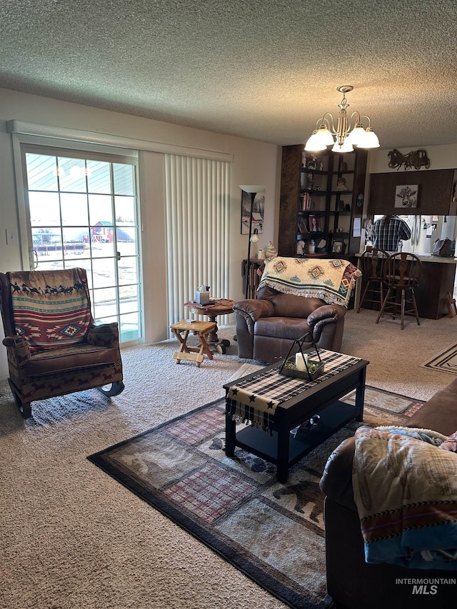 carpeted living area featuring a notable chandelier and a textured ceiling