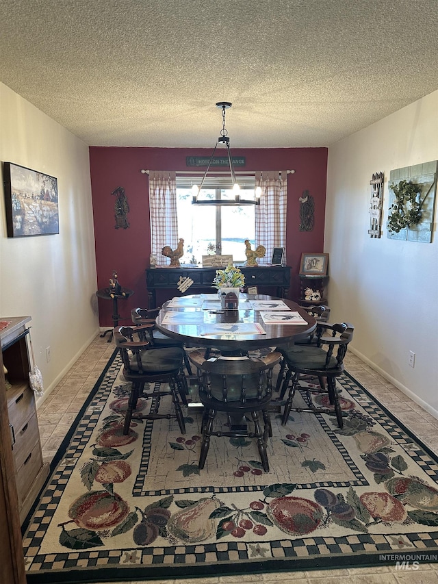 dining area featuring baseboards and a textured ceiling