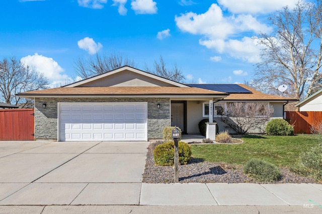 ranch-style home with stone siding, an attached garage, a front yard, and fence