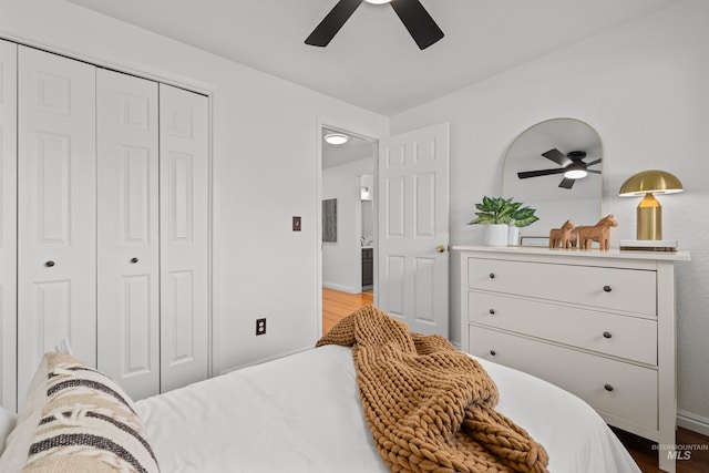 bedroom featuring baseboards, wood finished floors, a closet, and ceiling fan