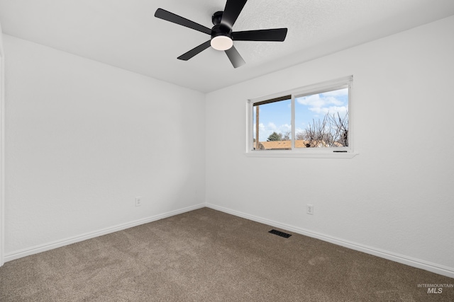 empty room featuring visible vents, a textured ceiling, carpet floors, baseboards, and ceiling fan