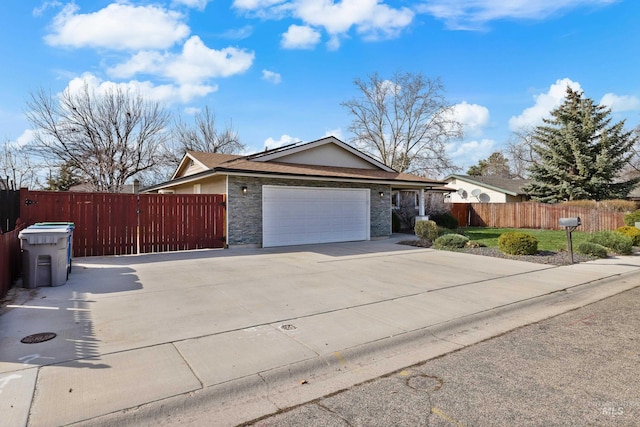 ranch-style home featuring stone siding, driveway, an attached garage, and fence