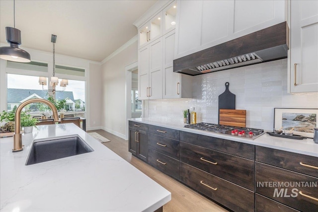 6201 W Redland Dr, Eagle, ID 83616 - kitchen with decorative backsplash, white cabinetry, under cabinet range hood, a sink, and stainless steel gas stovetop