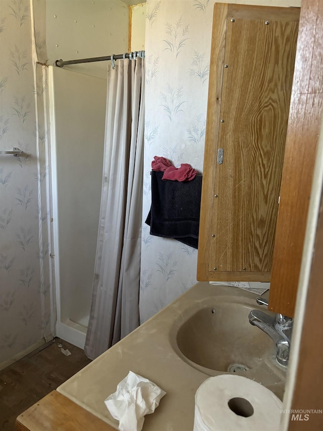 bathroom featuring wood-type flooring, sink, and curtained shower